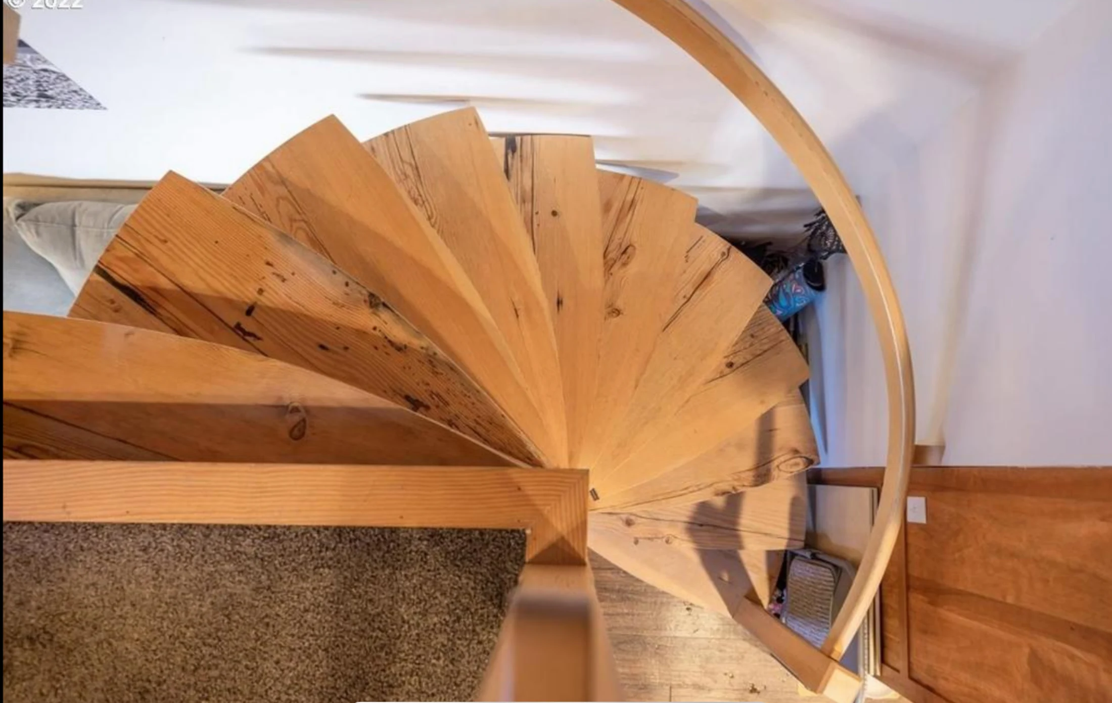 Top view of a custom natural wood spiral staircase and curved handrail